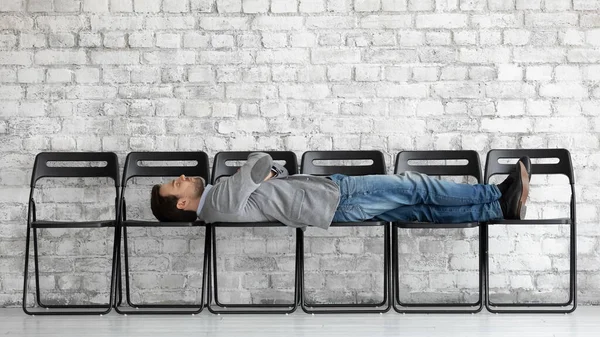 Znudzony kandydat leżący na krzesłach biurowych, czekający na rozmowę kwalifikacyjną — Zdjęcie stockowe