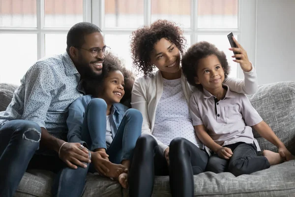 Famille ethnique souriante avec des enfants font selfie sur téléphone portable — Photo