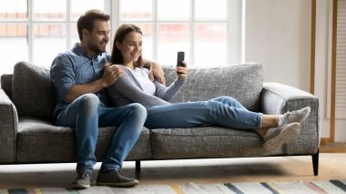 Rahat genç çift akıllı telefondan komik videolar izliyor..