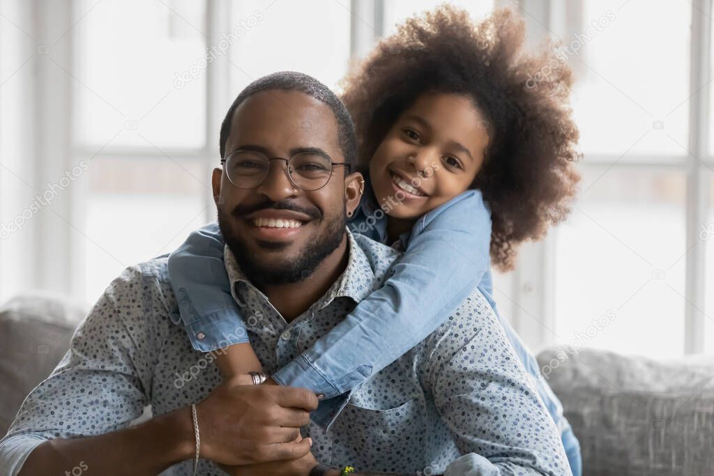 Portrait of happy african american dad and daughter cuddling