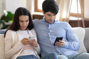 Teknolojiye bağımlı genç bir çift akıllı telefon kullanıyor..