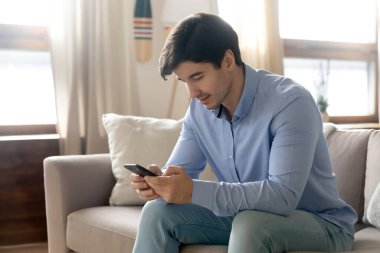 Akıllı telefon kullanan mutlu, genç ve yakışıklı bir adam..