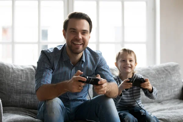 Joyeux jeune père jouant à des jeux vidéo avec le petit fils. — Photo