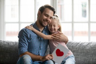 Minnettar, genç, gülümseyen, yakışıklı baba, kucaklayan küçük kız..