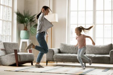 Enerjik genç anne evde küçük kızıyla dans ediyor..