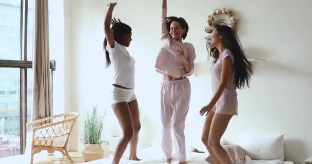 Overgelukkig jong multiraciaal vrouwen in pyjama genieten partij. — Stockvideo