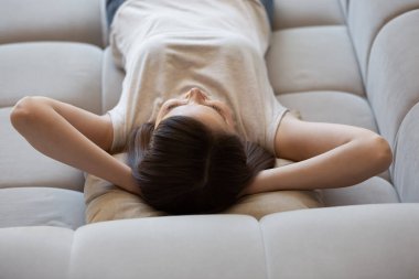 Huzurlu genç bayan evdeki yumuşak koltukta dinleniyor.