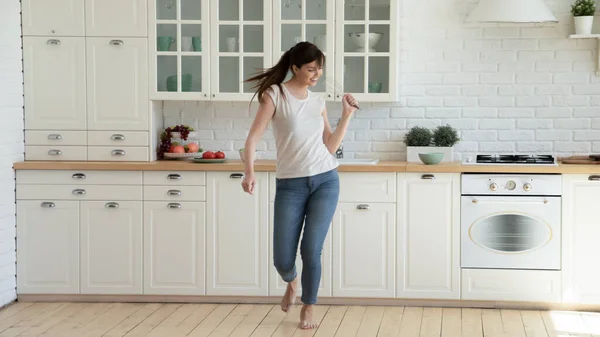 Happy joyful young woman dancing and singing at kitchen — Stock Photo, Image