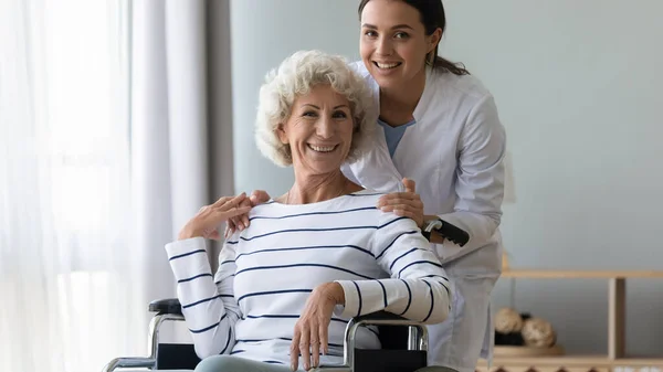 Retrato de joven terapeuta profesional sonriente con paciente discapacitado. —  Fotos de Stock