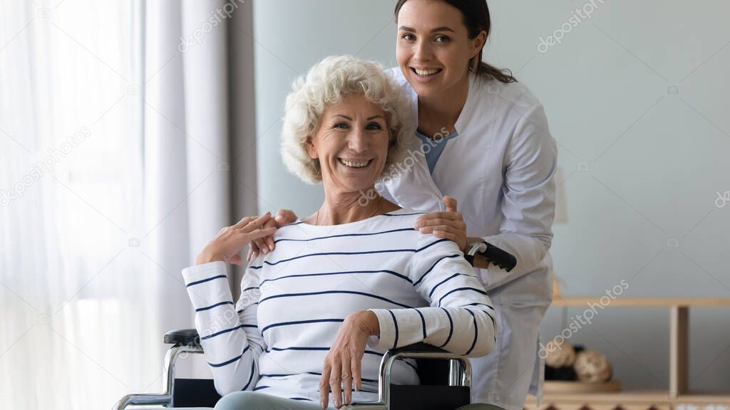 Portrait of smiling young professional therapist with disabled patient.