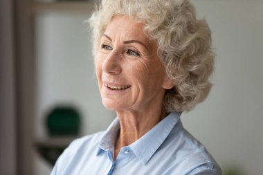 Mutlu, orta yaşlı, beyaz, geleceği hayal eden bir kadın..