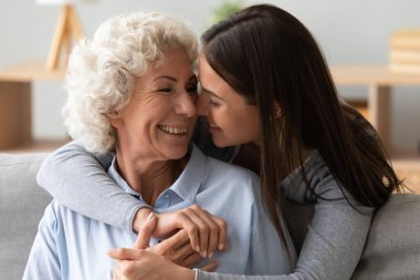 Sırtından sarılıp gülümseyen genç, güzel bir kadın..