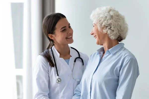 Cuidar a la enfermera milenaria ayudando al paciente de mediana edad en la reunión. —  Fotos de Stock