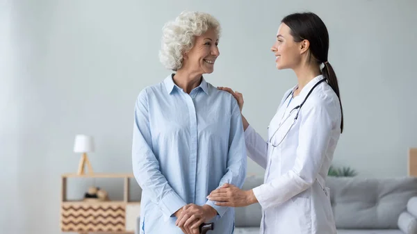 Sorridente donna disabile di mezza età che parla con fisioterapista donna. — Foto Stock