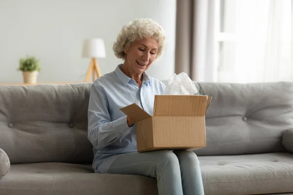 Sorrindo cliente feminino mais velho satisfeito com o serviço de entrega de correio rápido . — Fotografia de Stock