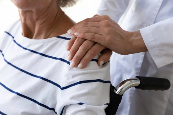 Giovane medico che dà aiuto psicologico ai pazienti anziani disabili. — Foto Stock