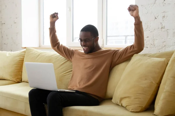 Glücklicher schwarzer Mann aufgeregt, gute Nachrichten zu Hause zu bekommen — Stockfoto