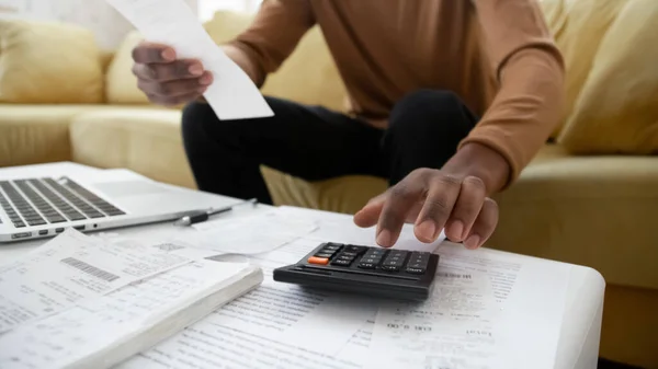 Black small business owner making calculations at home close up