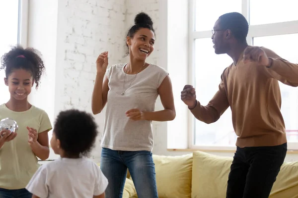 Glücklich lachende schwarze vierköpfige Familie tanzt zu Hause — Stockfoto
