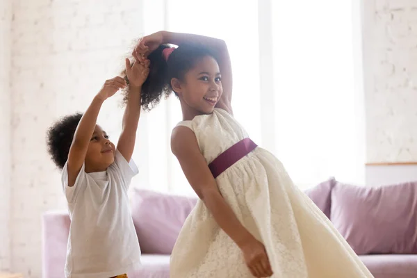 Sœur aînée noire dansant dans le salon avec son frère cadet — Photo