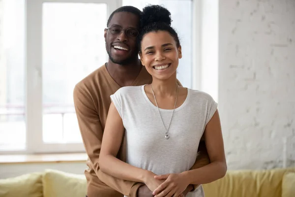 Retrato de feliz pareja africana milenaria abrazándose en nuevo apartamento — Foto de Stock