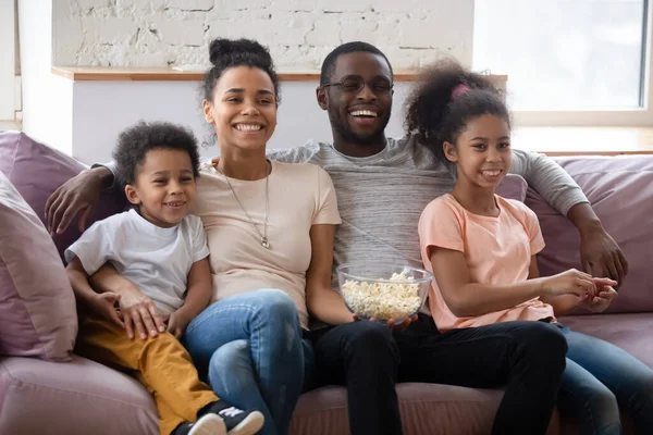 Feliz abrazo a la familia africana con niños viendo películas de televisión juntos — Foto de Stock