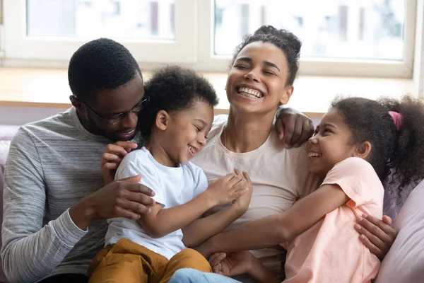 Les parents noirs affectueux chatouillent et ricanent avec les enfants à la maison — Photo