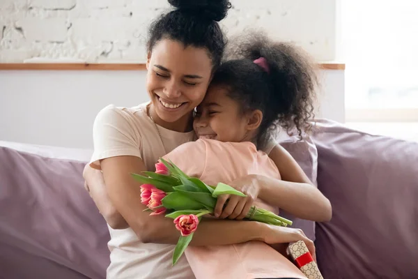 Feliz madre negra abrazando a su hija recibiendo felicitaciones en el Día de las Madres — Foto de Stock