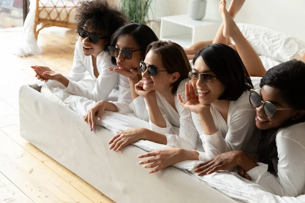 Mädchen mit Sonnenbrille liegen beim Fotoshooting im Bett und feiern Polterabend — Stockfoto
