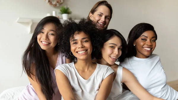 Fem underbara unga glada flickor ler poserar sittande i sängen — Stockfoto