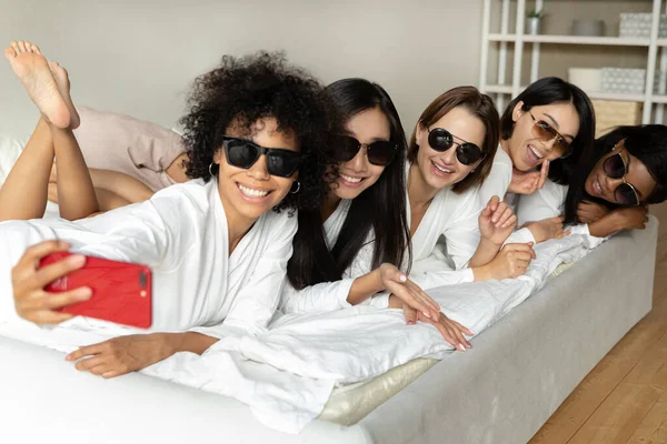 African girl taking selfie with best friends lying in bed — Stock Photo, Image