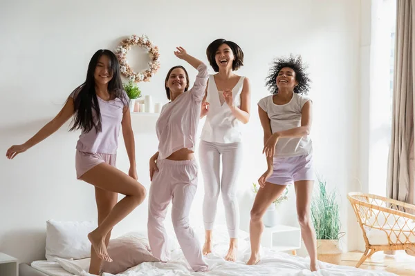 Сексуальні дівчата висять разом слухаючи музику, танцюючи в ліжку — стокове фото