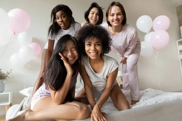 Diversas chicas en pijama mirando a la cámara que se divierten en el interior — Foto de Stock