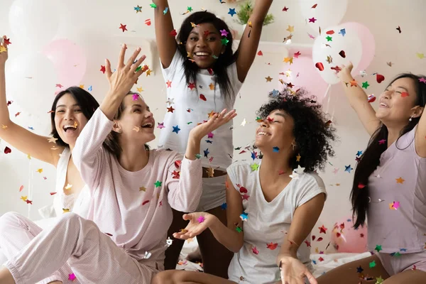 Multiétnico sexy jovens garotas rindo captura caindo confete multi colorido — Fotografia de Stock