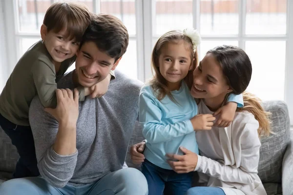 Gelukkige schattige kleine kinderen knuffelen liefdevolle liefhebbende ouders. — Stockfoto