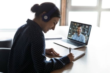 Eğitmen Webinar dinleyen, notlar yazan mutlu ırk kızı.