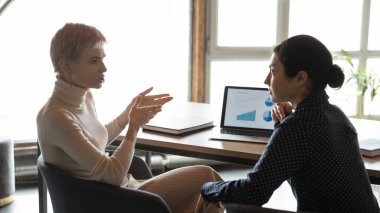 Ciddi sarışın şirket lideri Hintli çalışanlarla istatistik tartışıyor..