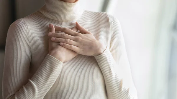 Close up focus on female hands, folded on chest. — Stock Photo, Image