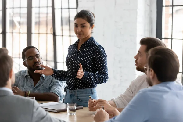 Confident Indian businesswoman mentor speaking at corporate meeting