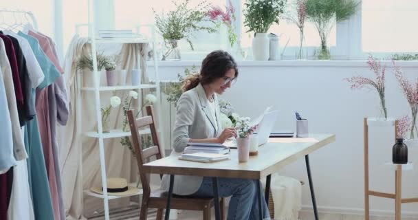 Nachdenkliche junge kreative Geschäftsfrau entwickelt Kleidungsdesign im Büro. — Stockvideo