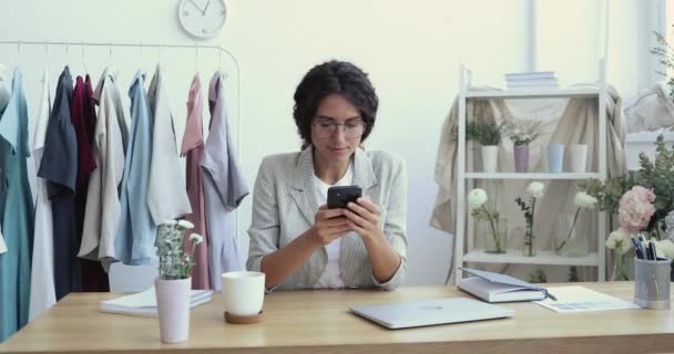 Ελκυστική νεαρή γυναίκα επιχειρηματίας χρησιμοποιώντας smartphone σε μπουτίκ. — Αρχείο Βίντεο