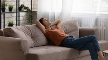 Genç bayan kanepede dinleniyor.