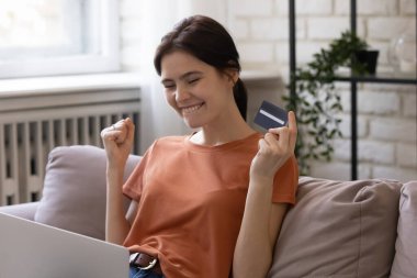 Heyecanlı kız dizüstü bilgisayardan alışveriş yapmaktan çok memnun.
