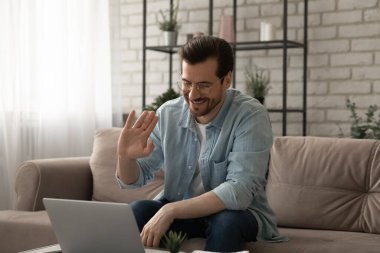 Gülümseyen adam dalgası bilgisayardaki video görüşmesinde konuşuyor