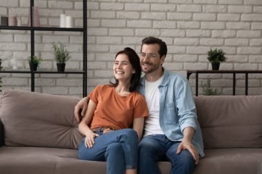 Mutlu genç çift evdeki kanepede dinleniyor.