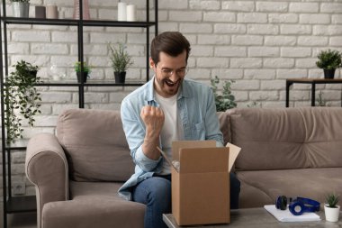 Heyecanlı adam kaliteli ürünle tatmin edilmiş paket açma siparişi
