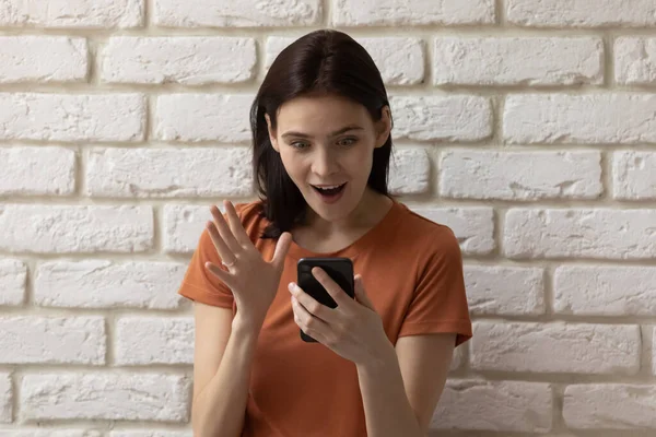 Excited girl shocked by sale deal on smartphone — Stock Photo, Image