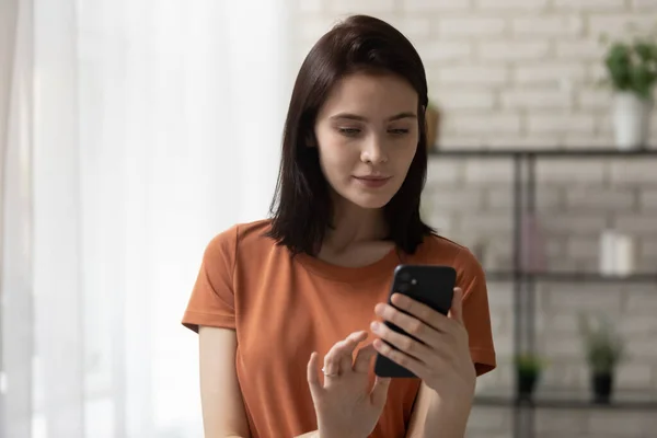 Millennial meisje kijken naar mobiele telefoon scherm surfen op internet — Stockfoto