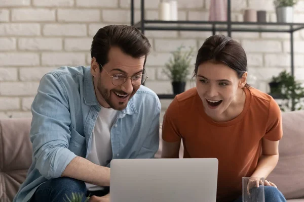 Amazed Caucasian couple shocked by unexpected online offer — Stock Photo, Image