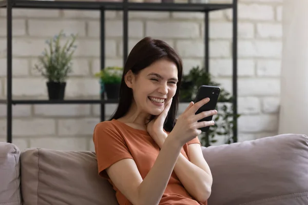 Smiling girl have fun watching funny video on cell — Stock Photo, Image